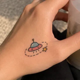 Small colorful ufo and star hand tattoo