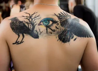 Raven and eye of horus back tattoo