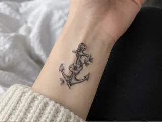 Small anchor and flower wrist tattoo