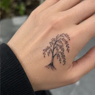 Minimalist fine line willow tree hand tattoo