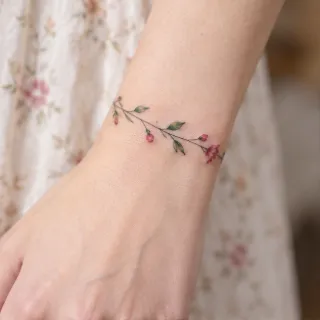 Fine line floral vine bracelet wrist tattoo