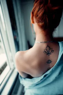 Fine line lotus and geometric spine tattoo