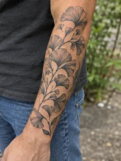 Black and grey ginkgo leaf branch forearm tattoo