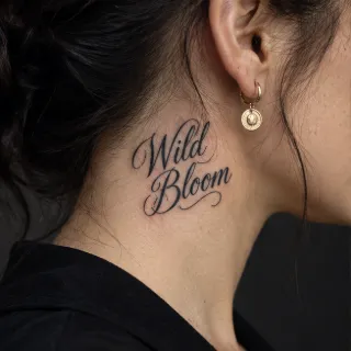 Wild bloom cursive script lettering neck tattoo