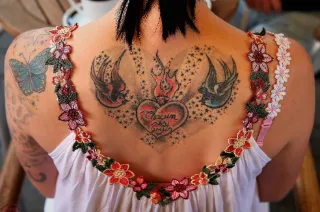 Traditional swallow and flaming heart back tattoo