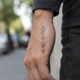 Minimalist geometric arrow and dot hand tattoo