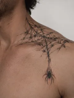 Blackwork spider and web shoulder and neck tattoo