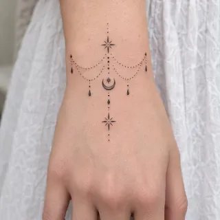 Fine line celestial moon and star jewelry wrist tattoo