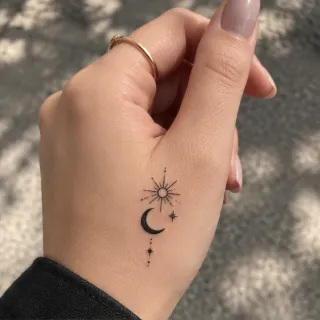 Fine line sun moon and stars hand tattoo
