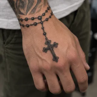Black and grey rosary beads with cross hand tattoo
