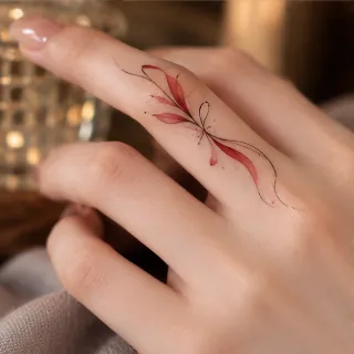 Fine line red botanical leaf finger tattoo
