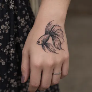 Fine line betta fish hand tattoo