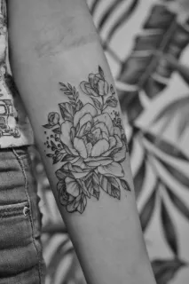 Black and grey floral bouquet forearm tattoo