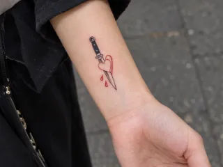 Small dagger and heart forearm tattoo