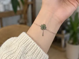 Fine line clover bracelet with charm wrist tattoo