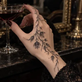 Fine line floral vine hand and finger tattoo