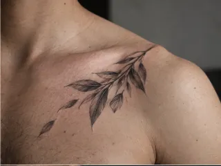 Fine line botanical leaf branch collarbone tattoo