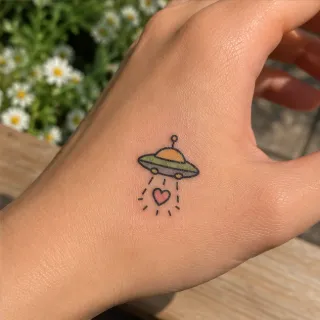 Small colorful ufo and heart hand tattoo