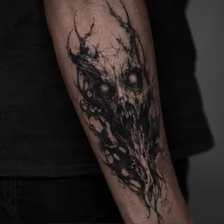 Dark surrealist skull and abstract creature forearm tattoo