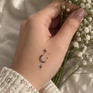 Minimalist fine line crescent moon and stars hand tattoo