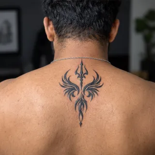 Blackwork trident and wings symbol upper back tattoo
