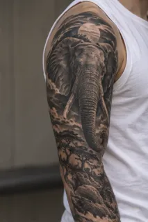 Realism elephant and savanna landscape upper arm tattoo