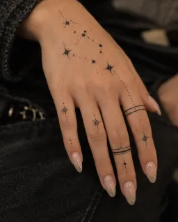 Fine line celestial stars and geometric ring hand tattoo