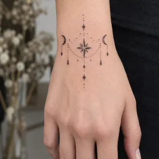 Fine line celestial star and moon hand tattoo