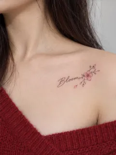 Fine line bloom lettering and cherry blossom collarbone tattoo