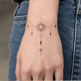 Fine line sun and celestial jewelry style hand tattoo
