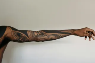 Blackwork abstract fluid line and geometric pattern arm sleeve tattoo