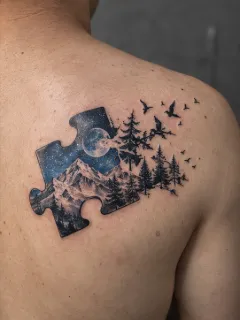 Puzzle piece mountain forest and birds shoulder tattoo