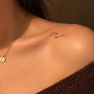 Minimalist fine line ocean wave collarbone tattoo