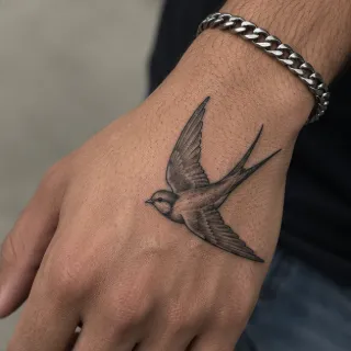 Small black and grey swallow bird hand tattoo