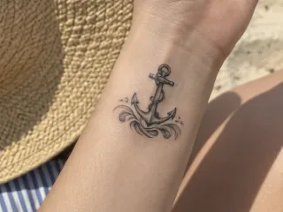 Small anchor and waves wrist tattoo