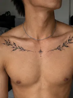 Fine line leaf branches and star chest tattoo