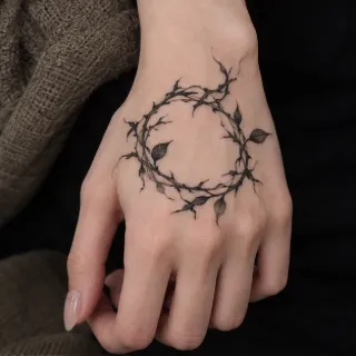 Fine line thorny vine wreath hand tattoo