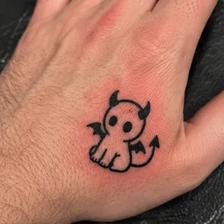 Small minimalist cartoon devil hand tattoo